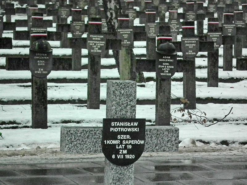 Powązki Wojskowe. Na pierwszym palnie nowy, granitowy krzyż. W tle stare. Fot. Piotr Weldon