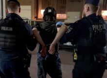 Policjanci prowadzą podejrzanego na przesłuchanie